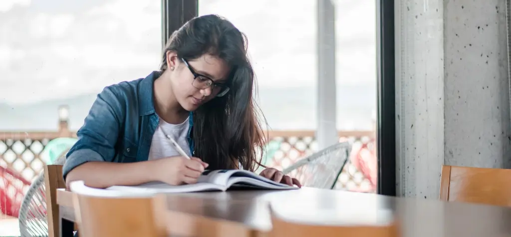 Girl sitting alone at a table and working