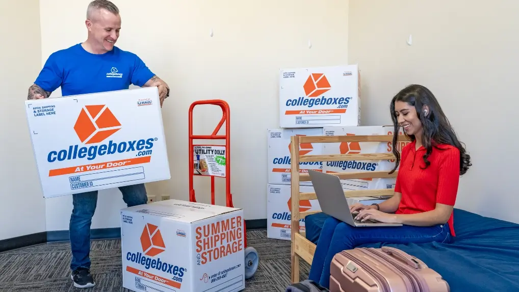 Photo of a person loading Collegeboxes branded boxes onto a dolly.