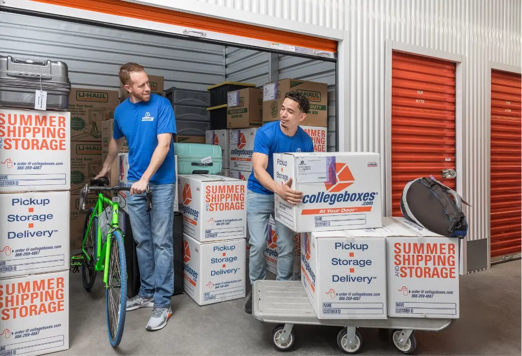 Two people loading Collegeboxes branded boxes into a storage container